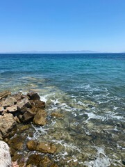 Beautiful view of the rocky beach and the skyline, blue water in the sea and clear sky