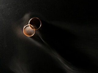 Gold wedding rings with smoke on black background