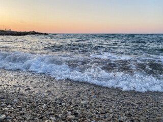 Sea wave at sunset close-up with splashes, sea background