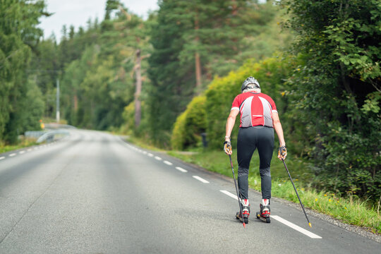 Senior male roller skiing on asphalt road. Sports and healthy concept.