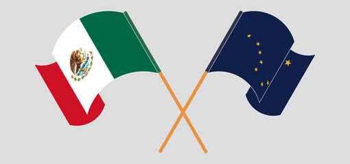 Crossed and waving flags of Mexico and the State of Alaska