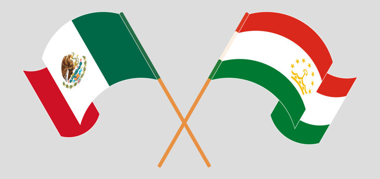Crossed and waving flags of Mexico and Tajikistan