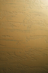 Phone wallpaper of golden gradient plaster background.Vertical format