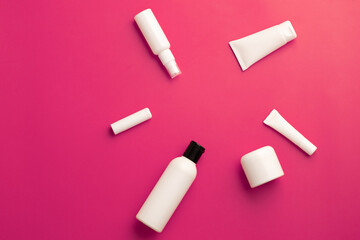 flat lay with cosmetic products tubes branding on pink background