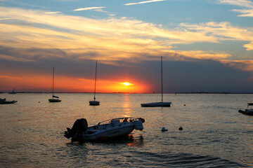 Naklejka premium Sun set in background with moored boats in foreground