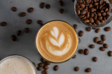 Close up a cup of latte with flower foam,milk,coffee beans.Top view