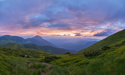 Lovely dawn in the mountains. The rising sun illuminates the pink clouds. Beautiful mountain landscape in the Ukrainian Carpathians