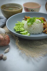 Hainanese chicken rice with fried chicken, fried chicken served with sweet dipping sauce and chicken broth, Asian style, street food commonly sold in Asia.