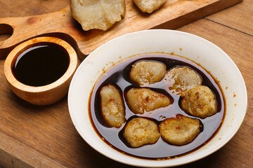 empek empek with cuka or vinegar sauce in a white bowl. emepek enpek is a typical food from Palembang Indonesia. pempek palembang. Indonesian dish