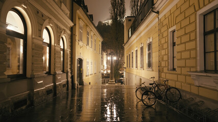 Walk through narrow alley at night in rain reflections of lights
