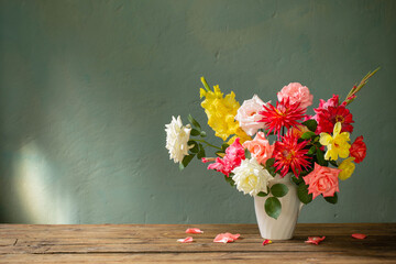 autumn bouquet with red and yellow flowers in white vase on dark background - obrazy, fototapety, plakaty