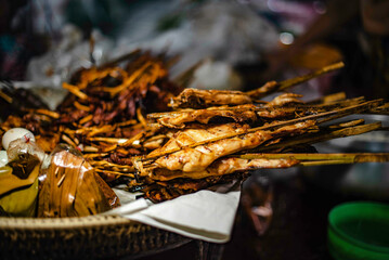 Grilled chicken skewed with bamboo and steamed on a tray for sale in a fresh market in Ubon Ratchathani, Thailand.