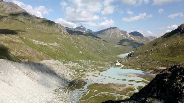 Aerial view of a high mountain lake in the valley of Zinal, Switzerland. Big shadows of the moving clouds