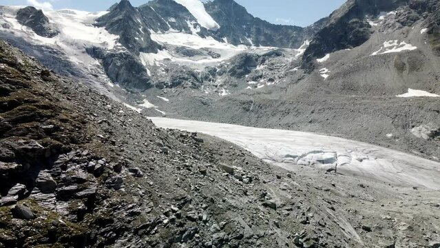 Slow tilt up aerial view revealing a huge glacier in Zinal valley, Switzerland