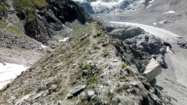 Very fast aerial FPV like shot moving forward tracing the shape of the mountain in Zinal, Switzerland