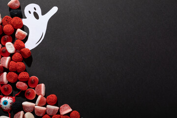 Multiple halloween candies and ghost toy with copy space on grey background - Powered by Adobe
