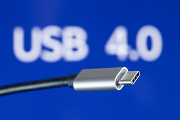 USB4 plug cable on blue background with USB 4.0 text. New computer USB protocol