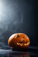 Fototapeten Close up of carved halloween pumpkin against smoke effect on grey background © wavebreak3