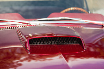 The hood of a retro muscle car with air intake slot for a turbocharged engine. Front view oldtimer...