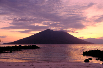 Naklejka na ściany i meble Indonesia Alor Island - Rocky beach and vulcano at sunset