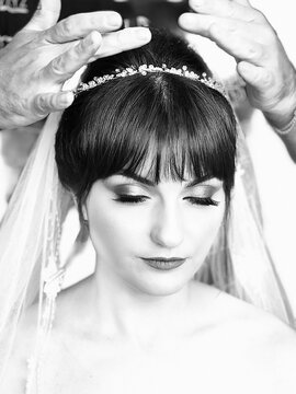 A hairdresser is making the hairstyle of a young girl bride's head in a hair salon - Black and White photo