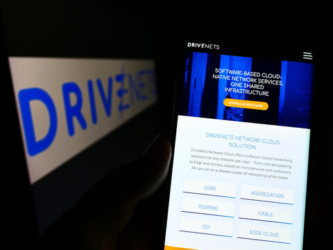 Stuttgart, Germany - 09-04-2022: Person holding cellphone with website of Israeli software company DriveNets Ltd. on screen in front of logo. Focus on center of phone display.