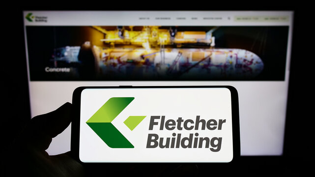 Stuttgart, Germany - 09-04-2022: Person holding smartphone with logo of construction company Fletcher Building Limited on screen in front of website. Focus on phone display.