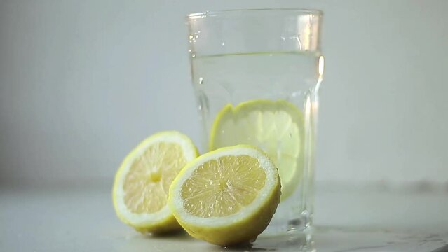 slice lemon fruit in glass of water on table with white background stock footage