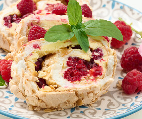 Baked meringue roll with cream and fresh red raspberry, white background
