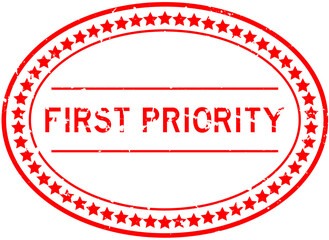 Grunge red first priority word oval rubber seal stamp on white background