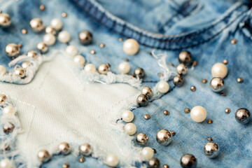 Fototapeta na wymiar Jeans background clothing. Denim fabric closeup. Textures of clothing made of fabric with fashionable embroidery of pearl beads. Copy space for text. Fashionable style.