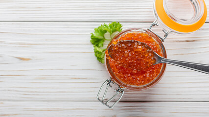 Red caviar with parsley in jar and spoon