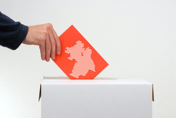 In Niedersachsen wird gewählt - Hand mit Stimmzettel und Wahlurne