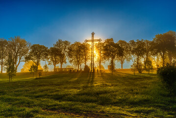 the sunset behind the cross