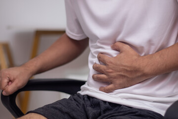 Fototapeta premium Man's hand holding his stomach touch the pain area