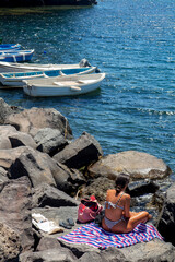tourist on rocks in Ischia and boat