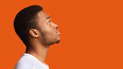Side View Of Serious Black Guy Posing Over Orange Background