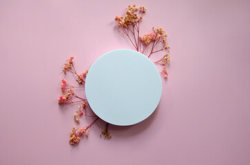 Obraz na płótnie Canvas horizontal Flatlay white circle Mockup on a pink background on light pink flowers arranged in small twigs around