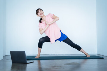 Fototapeta premium オンラインでヨガをする女性