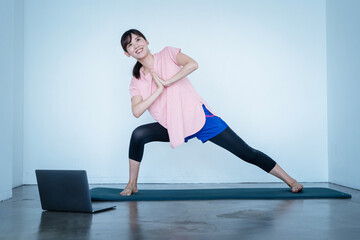 Fototapeta premium オンラインでヨガをする女性