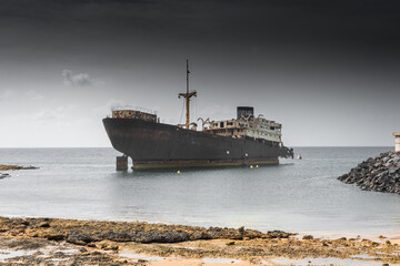 The Telamon shipwreck on the sea under a cloudy sky in Lanzarote Island , Spain