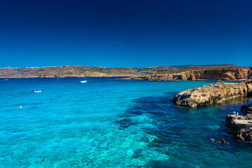 Comino, Malta, 22 May 2022:  Tourists swimming in the crystal clear water of the Blue Lagoon