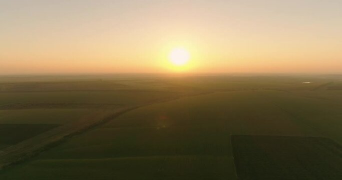 New day begining. Sun rising above harvested agriculture lands. Endless landscape of late summer morning