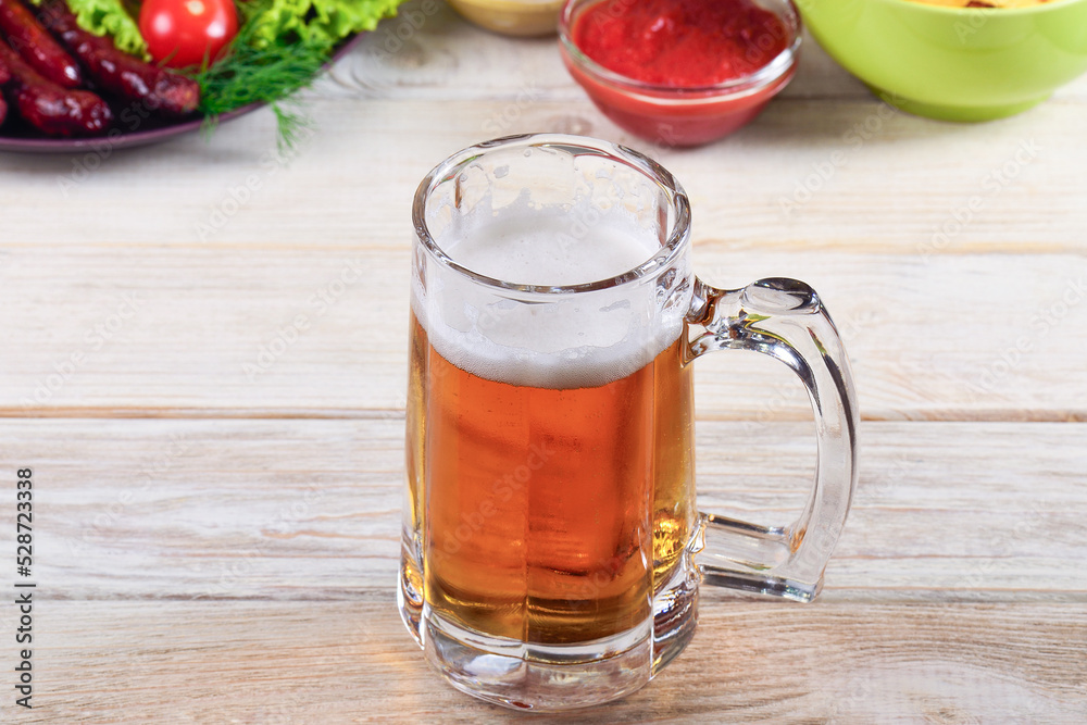 Wall mural glass of beer on a white table with a snack