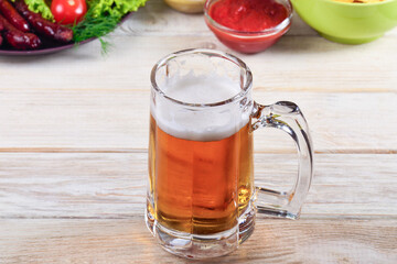 glass of beer on a white table with a snack