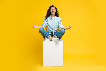 Middle Eastern Lady Meditating With Eyes Closed Over Yellow Background - obrazy, fototapety, plakaty