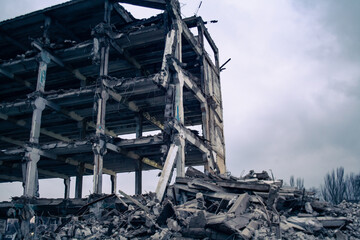 Concept of the war in Ukraine with Russia. Ruined house in an urban environment. Destruction сonsequences of shelling by artillery shells and air strikes on a residential area.