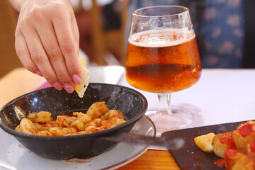 fried shrimps with lemon slice, garlic sauce aioli and tomato ketchup frying pan close up photo with beer