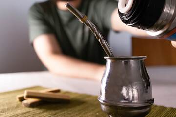 Man making a Mate, argentinian and uruguayan traditional drink, with cookies