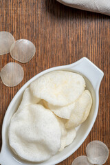 Crispy prawn crackers, deep fried, are served in an oval dish as a starter. Top view.